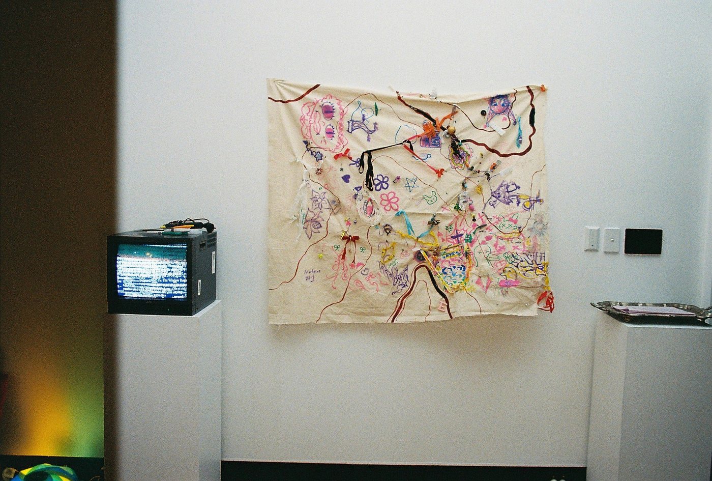 A finished map hung on the gallery wall beside a CRT monitor